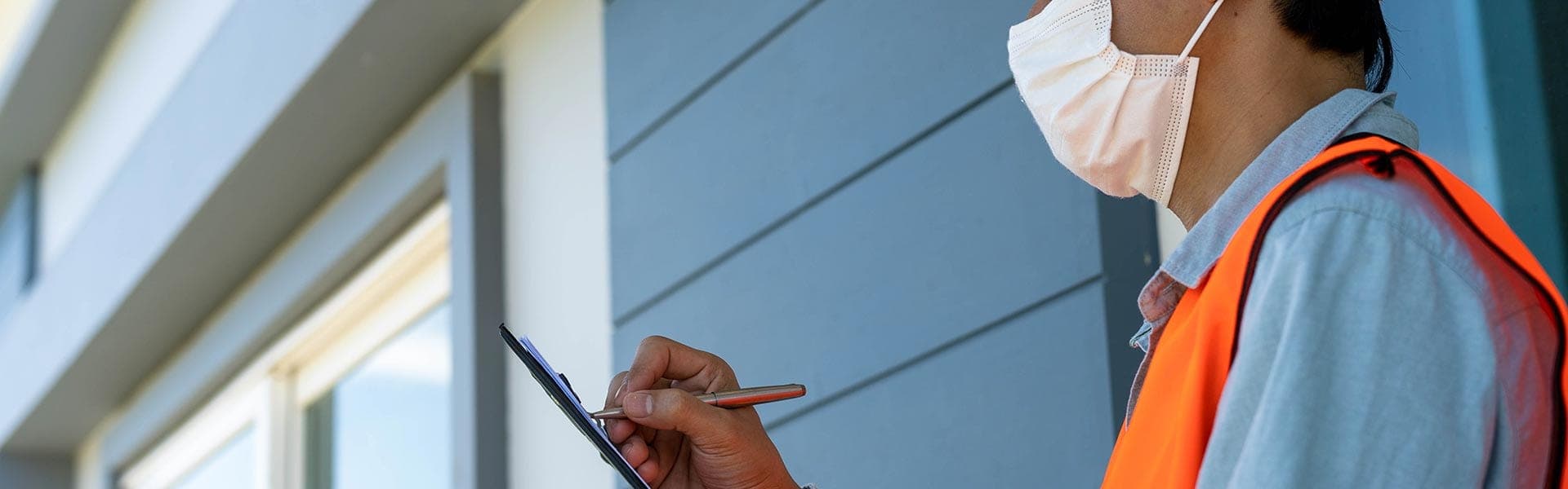 Asbestdeskundige inspecteert de gevel van een woning